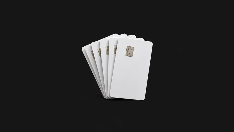 Isolated a stack of blank white chip cards fanned on edge centred on a seamless deep charcoal near-black studio background, generous empty margin on every side for overlaid branding