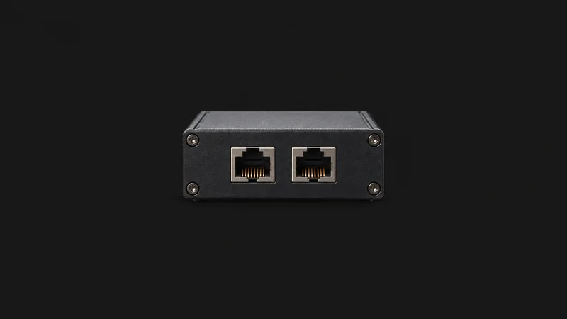 Isolated an inline network tap with paired copper ports centred on a seamless deep charcoal near-black studio background, generous empty margin on every side for overlaid branding