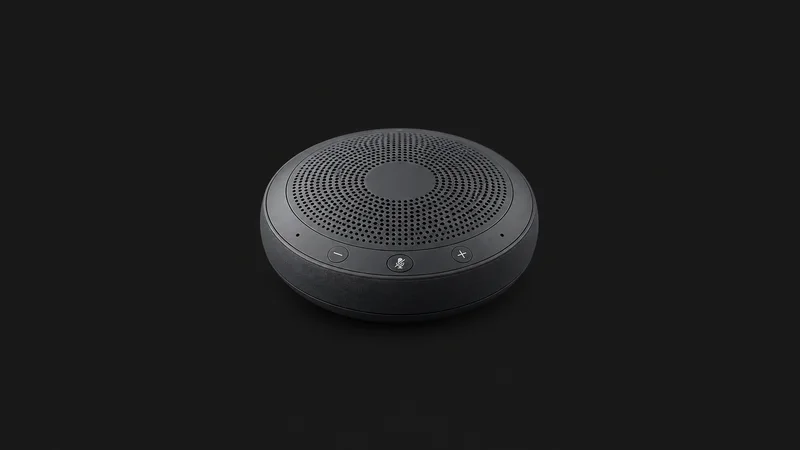 Isolated a wireless conference speakerphone puck for remote interviews centred on a seamless deep charcoal near-black studio background, generous empty margin on every side for overlaid branding