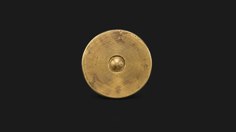 Isolated a brass property boundary marker disc centred on a seamless deep charcoal near-black studio background, generous empty margin on every side for overlaid branding