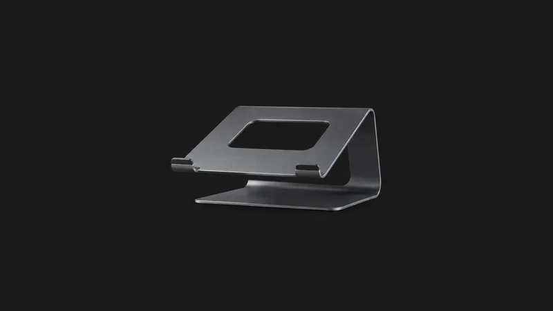 Isolated a laptop stand of folded bent aluminium centred on a seamless deep charcoal near-black studio background, generous empty margin on every side for overlaid branding