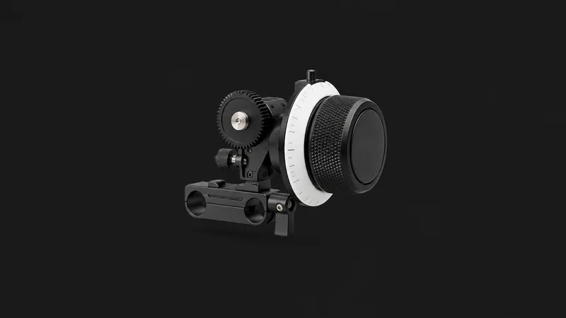 Isolated a follow-focus unit with a marked white disc centred on a seamless deep charcoal near-black studio background, generous empty margin on every side for overlaid branding