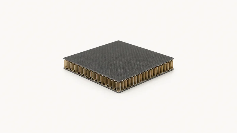 Isolated a cured honeycomb-core sandwich panel section centred on a seamless pale off-white studio background, generous empty margin on every side for overlaid branding