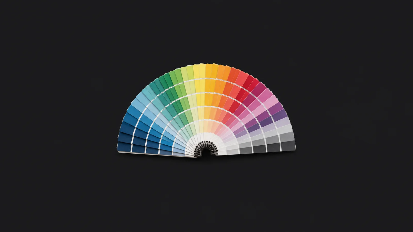 Isolated a spiral-bound cmyk colour-swatch fan opened in a half circle centred on a seamless deep charcoal near-black studio background, generous empty margin on every side for overlaid branding