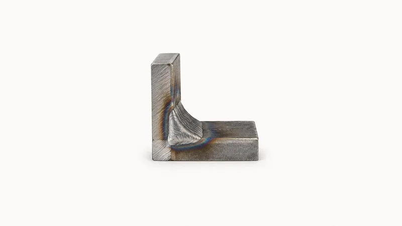 Isolated a welded steel corner joint cut for macro inspection centred on a seamless pale off-white studio background, generous empty margin on every side for overlaid branding