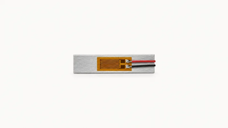 Isolated a strain gauge mounted on a small aluminium strip centred on a seamless pale off-white studio background, generous empty margin on every side for overlaid branding