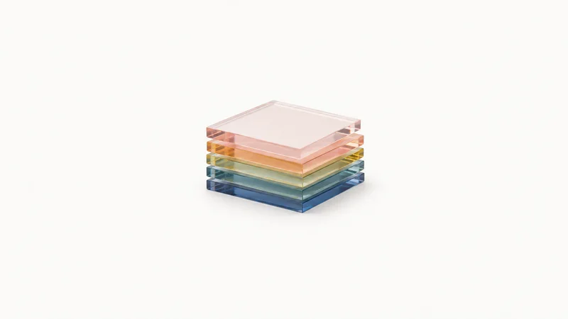 Isolated a set of tinted acrylic colour tiles stacked in a gradient centred on a seamless pale off-white studio background, generous empty margin on every side for overlaid branding