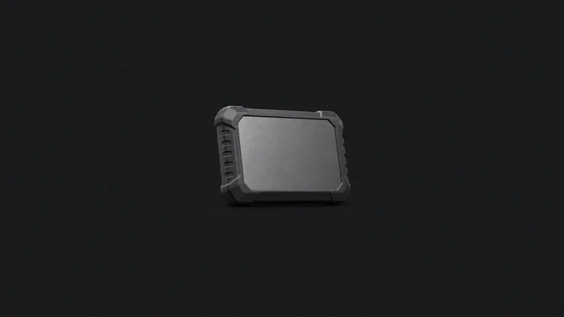 Isolated a portable SSD in a rubber sleeve centred on a seamless deep charcoal near-black studio background, generous empty margin on every side for overlaid branding