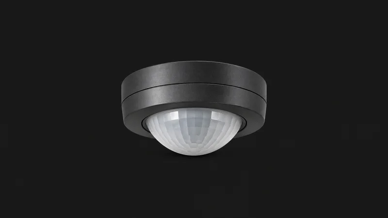 Isolated a ceiling-mount occupancy sensor with a domed lens centred on a seamless deep charcoal near-black studio background, generous empty margin on every side for overlaid branding