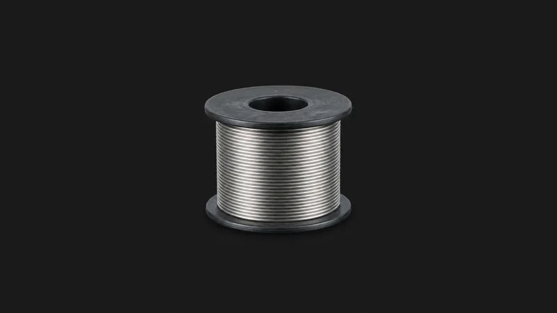 Isolated a spool of lead-free solder wire centred on a seamless deep charcoal near-black studio background, generous empty margin on every side for overlaid branding