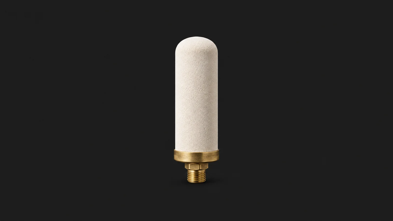 Isolated a ceramic filter candle with a brass fitting centred on a seamless deep charcoal near-black studio background, generous empty margin on every side for overlaid branding