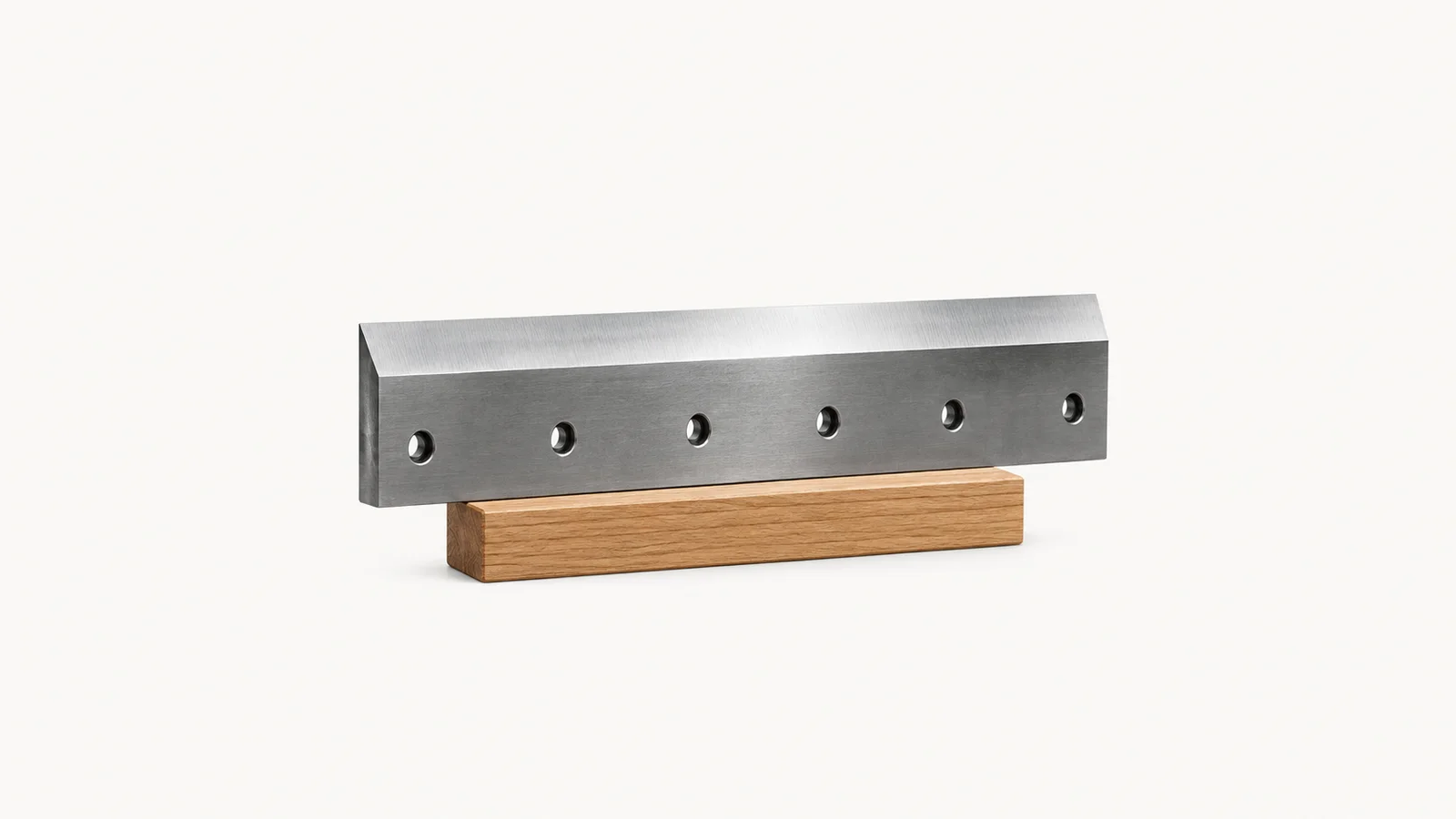 Isolated a thick steel guillotine blade with a honed bevel on a wooden block centred on a seamless pale off-white studio background, generous empty margin on every side for overlaid branding