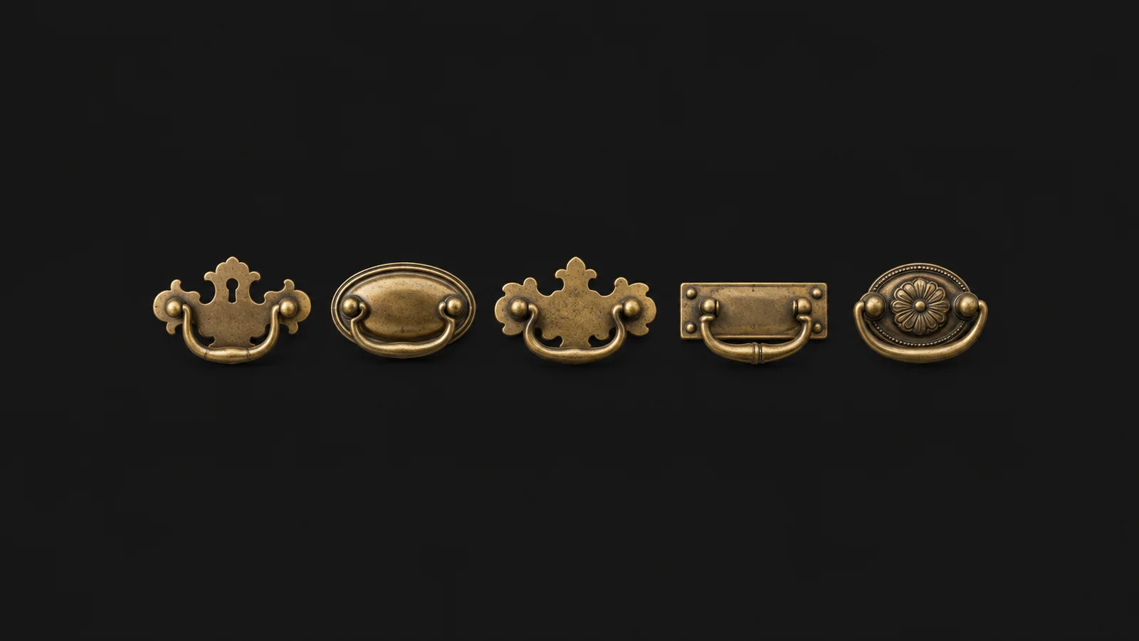Isolated a set of antique brass drawer pulls with backplates laid in a row centred on a seamless deep charcoal near-black studio background, generous empty margin on every side for overlaid branding
