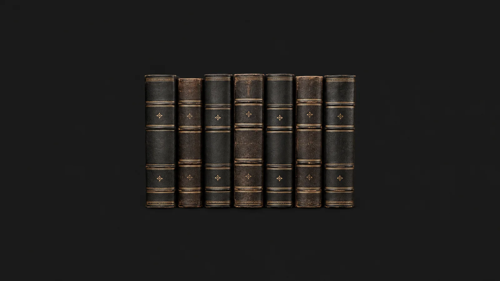 Isolated a row of gilt-spined bound law reports standing on end centred on a seamless deep charcoal near-black studio background, generous empty margin on every side for overlaid branding