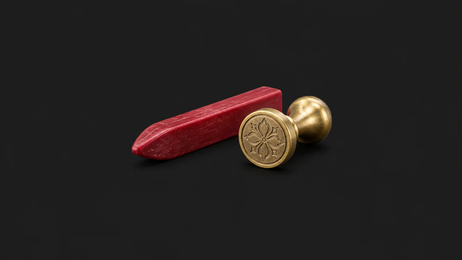 Isolated a stick of red sealing wax and a brass seal matrix centred on a seamless deep charcoal near-black studio background, generous empty margin on every side for overlaid branding