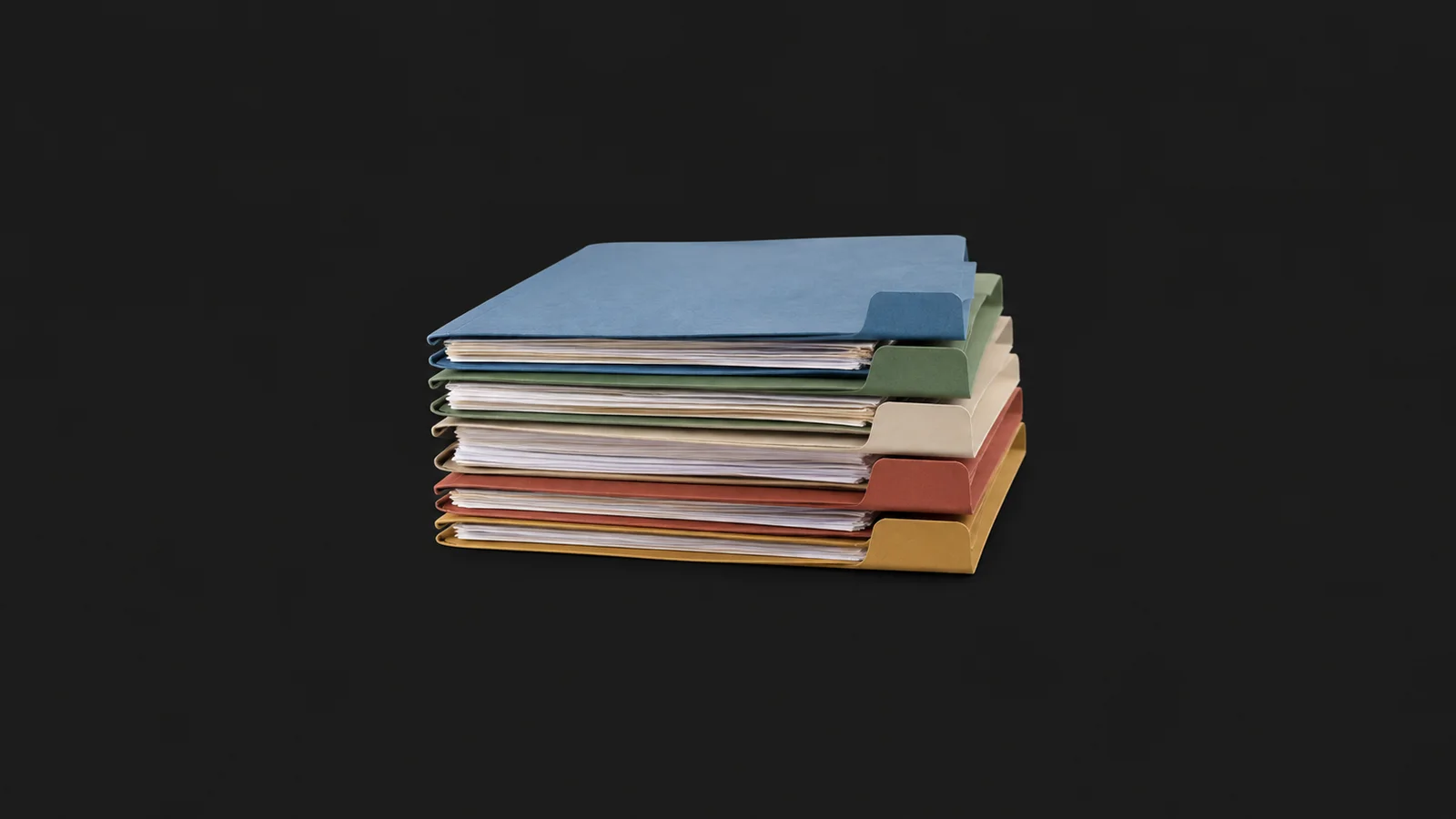 Isolated a stack of coloured document folders each with a tab flag centred on a seamless deep charcoal near-black studio background, generous empty margin on every side for overlaid branding