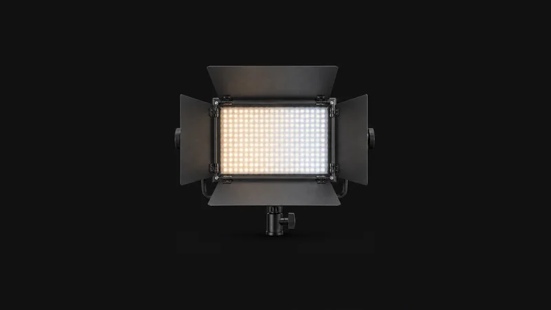 Isolated a bi-colour LED panel light with barn doors centred on a seamless deep charcoal near-black studio background, generous empty margin on every side for overlaid branding