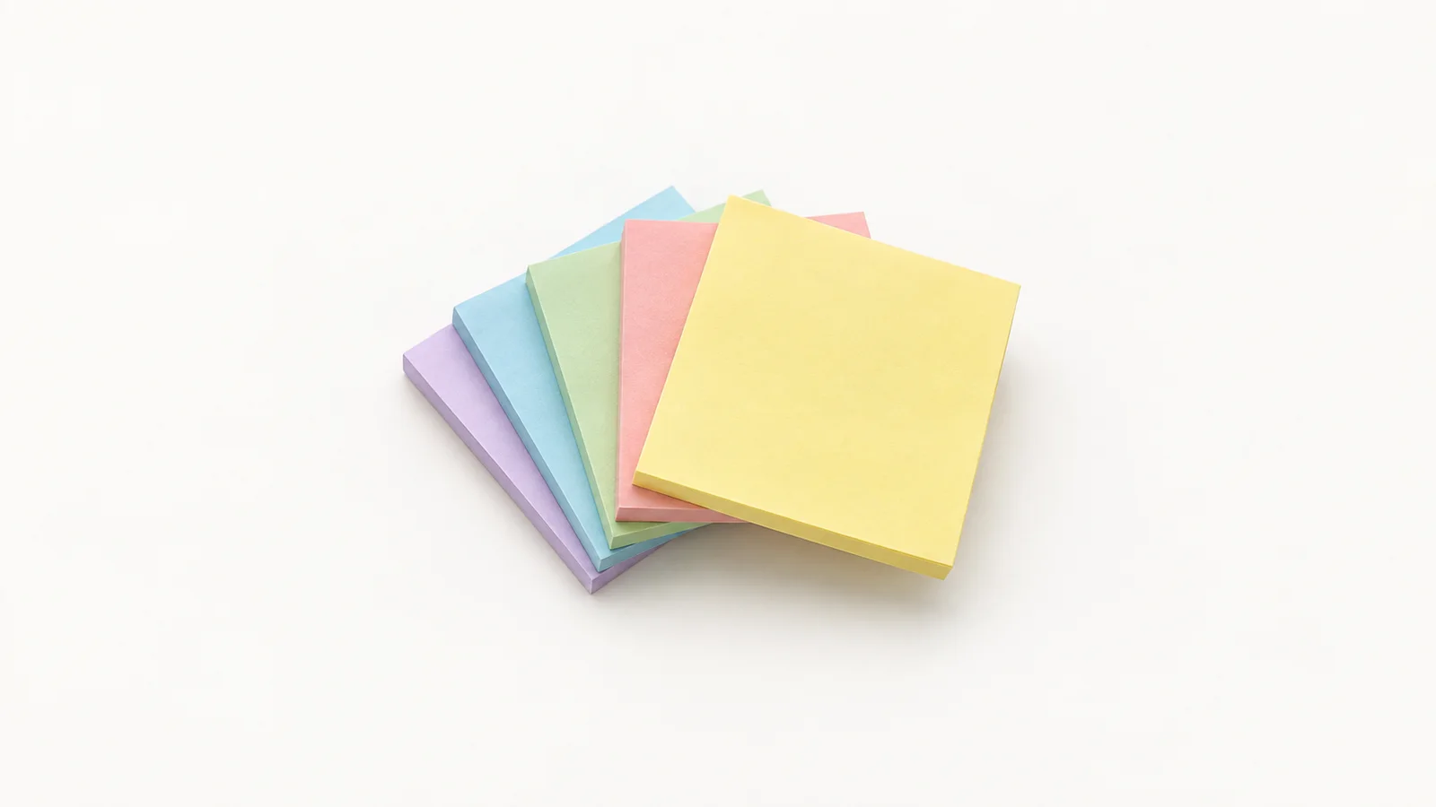 Isolated a set of coloured sticky-note pads in a fan centred on a seamless pale off-white studio background, generous empty margin on every side for overlaid branding