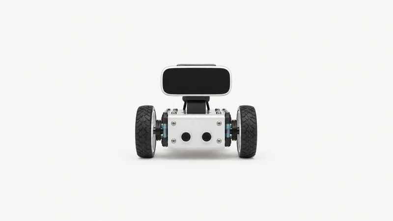 Isolated a small desktop robot kit with wheels and a blank sensor face centred on a seamless pale off-white studio background, generous empty margin on every side for overlaid branding