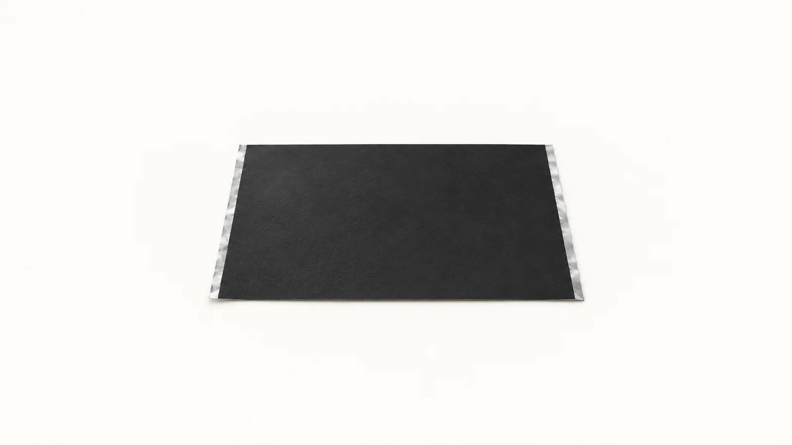 Isolated a sheet of black cathode coating on aluminium foil centred on a seamless pale off-white studio background, generous empty margin on every side for overlaid branding