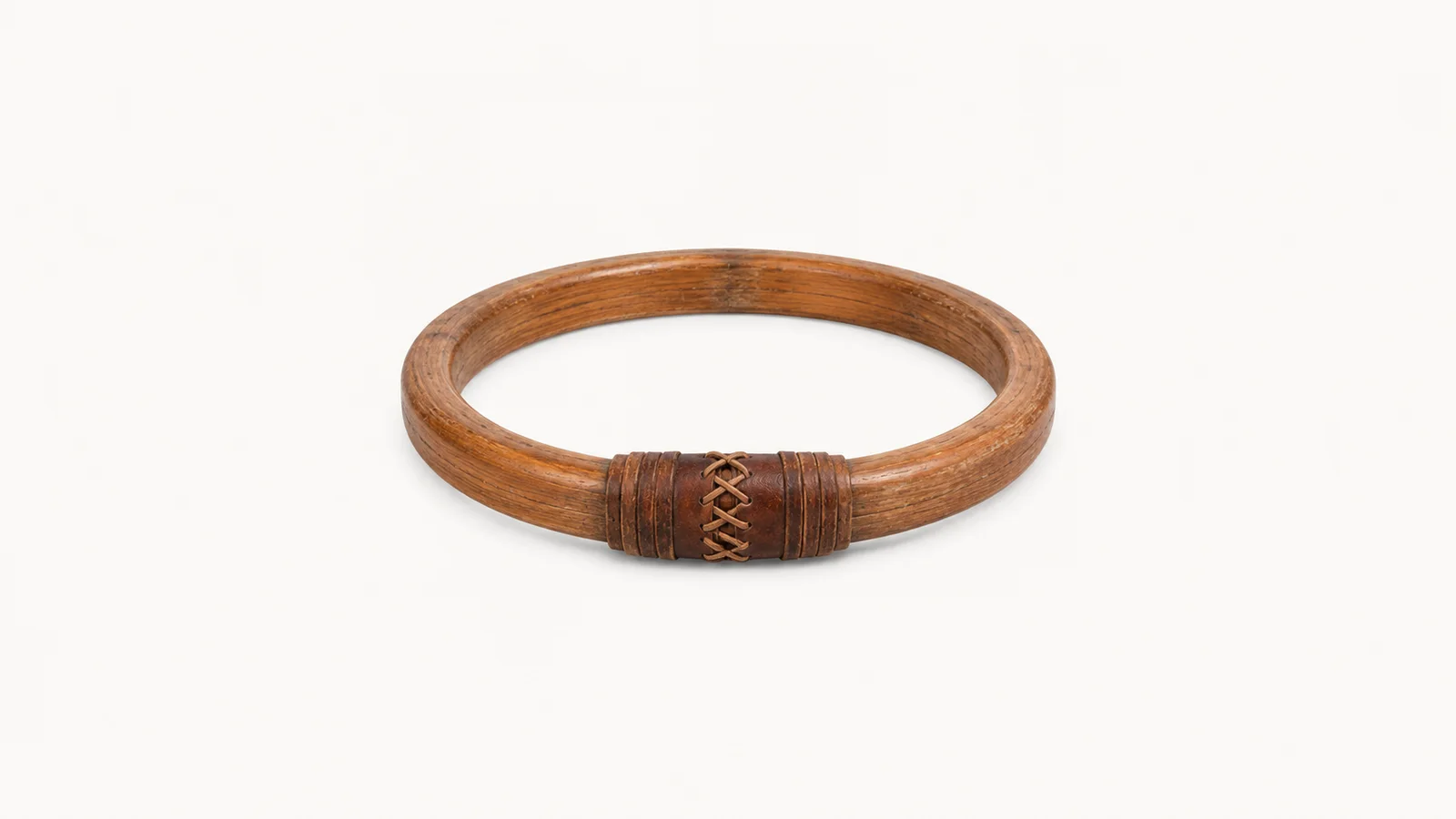 Isolated a wooden mast hoop with a leather-wrapped seizing centred on a seamless pale off-white studio background, generous empty margin on every side for overlaid branding
