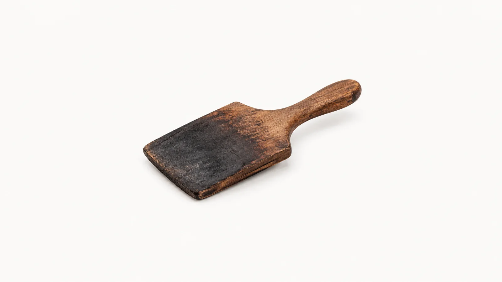 Isolated a wooden shaping paddle charred on its working face centred on a seamless pale off-white studio background, generous empty margin on every side for overlaid branding