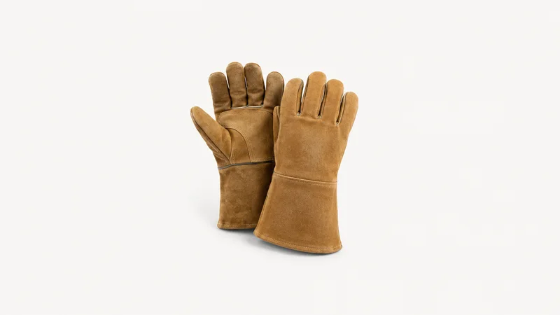 Isolated a pair of gauntlet welding gloves centred on a seamless pale off-white studio background, generous empty margin on every side for overlaid branding