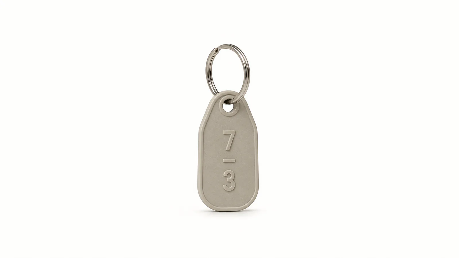 Isolated a numbered plastic key tag on a metal split ring centred on a seamless pale off-white studio background, generous empty margin on every side for overlaid branding