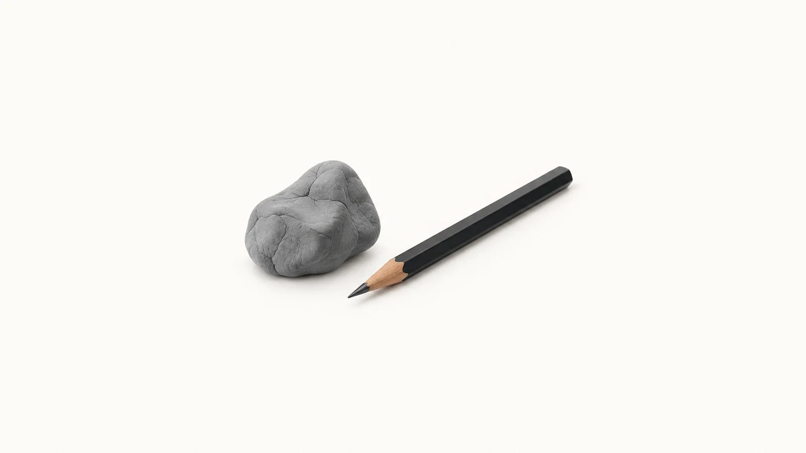 Isolated a kneaded eraser beside a graphite layout pencil centred on a seamless pale off-white studio background, generous empty margin on every side for overlaid branding