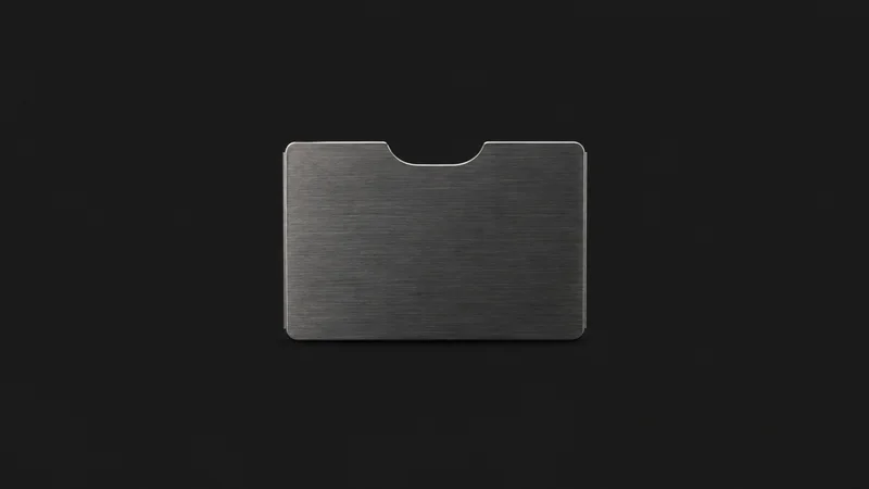 Isolated a RFID-blocking metal card sleeve centred on a seamless deep charcoal near-black studio background, generous empty margin on every side for overlaid branding