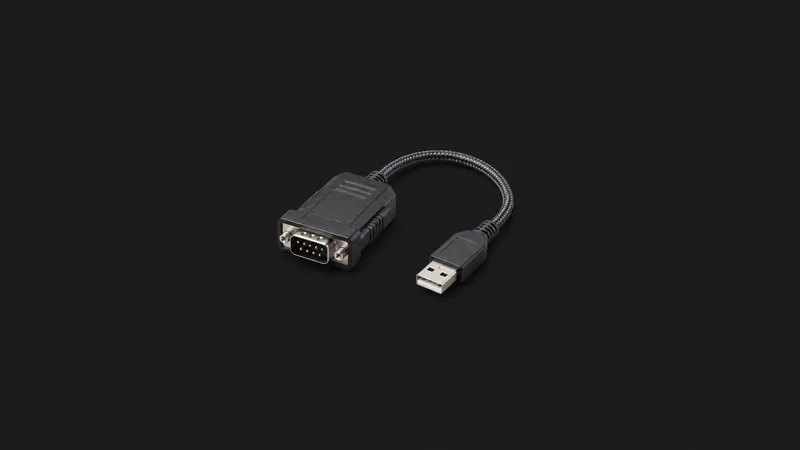 Isolated a rugged serial-console adapter with a braided lead centred on a seamless deep charcoal near-black studio background, generous empty margin on every side for overlaid branding