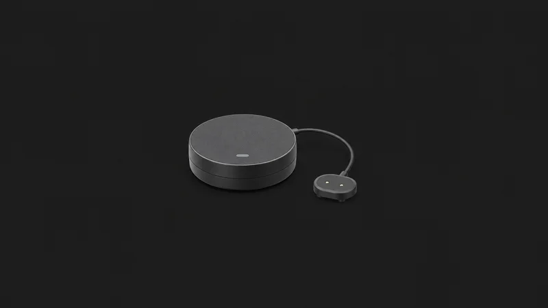 Isolated a smart water-leak detector puck with a small wired probe centred on a seamless deep charcoal near-black studio background, generous empty margin on every side for overlaid branding