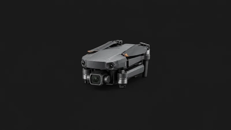 Isolated a compact drone with folded arms for roof inspection centred on a seamless deep charcoal near-black studio background, generous empty margin on every side for overlaid branding