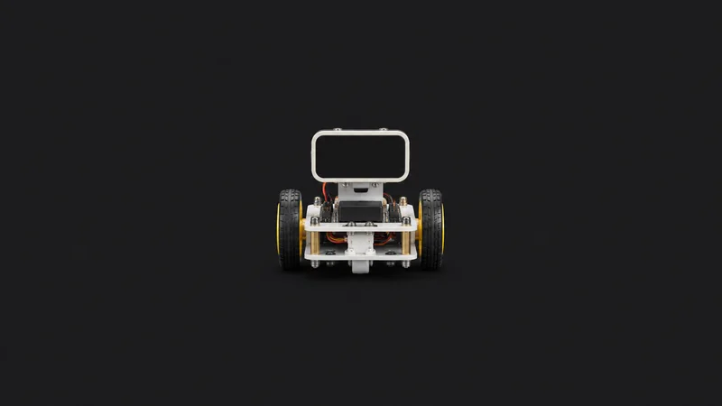 Isolated a small desktop robot kit with wheels and a blank sensor face centred on a seamless deep charcoal near-black studio background, generous empty margin on every side for overlaid branding