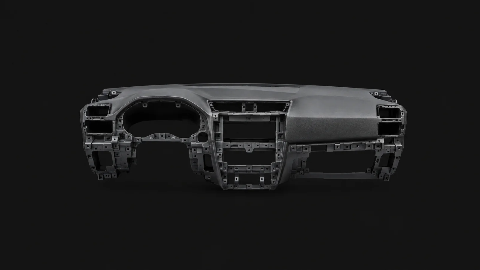Isolated a moulded car dashboard substrate without trim centred on a seamless deep charcoal near-black studio background, generous empty margin on every side for overlaid branding