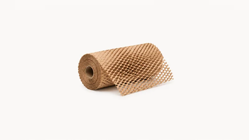 Isolated a rolled honeycomb paper wrap with a partly expanded edge centred on a seamless pale off-white studio background, generous empty margin on every side for overlaid branding
