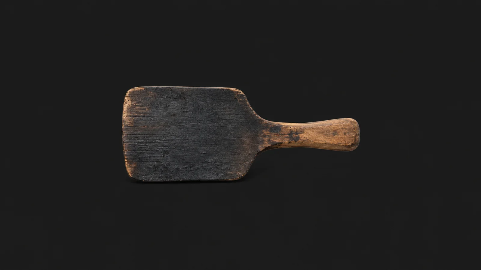 Isolated a wooden shaping paddle charred on its working face centred on a seamless deep charcoal near-black studio background, generous empty margin on every side for overlaid branding