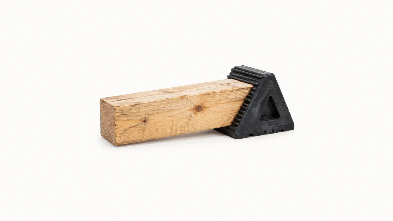 Isolated a wooden dunnage bar wedged with a rubber load-stop chock centred on a seamless pale off-white studio background, generous empty margin on every side for overlaid branding