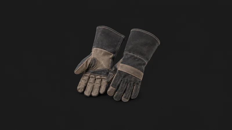 Isolated a pair of gauntlet welding gloves centred on a seamless deep charcoal near-black studio background, generous empty margin on every side for overlaid branding