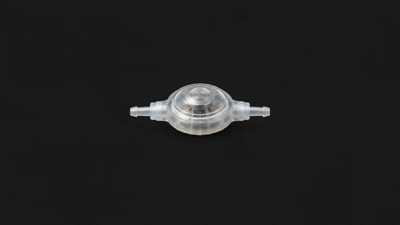 Isolated a silicone hydrocephalus shunt valve centred on a seamless deep charcoal near-black studio background, generous empty margin on every side for overlaid branding