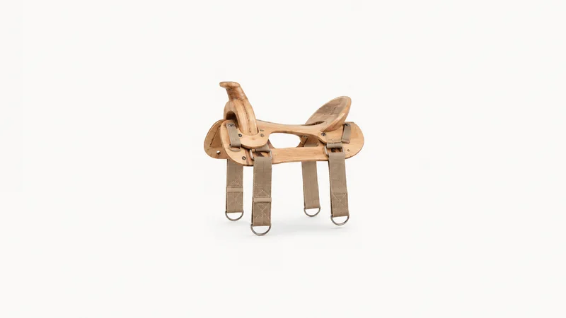 Isolated a wooden saddle tree with webbing straps centred on a seamless pale off-white studio background, generous empty margin on every side for overlaid branding