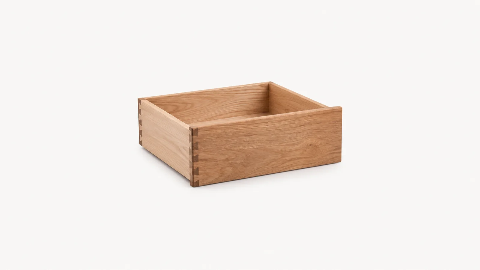 Isolated a cabinet drawer with hand-cut joints centred on a seamless pale off-white studio background, generous empty margin on every side for overlaid branding