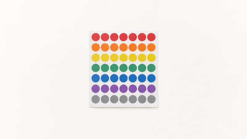 Isolated a set of colour-coded dot stickers on a sheet centred on a seamless pale off-white studio background, generous empty margin on every side for overlaid branding