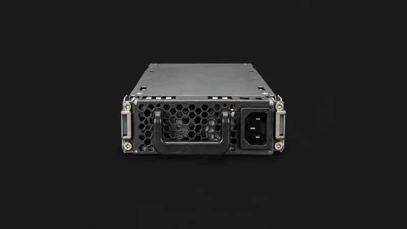 Isolated a redundant server power supply module with its handle centred on a seamless deep charcoal near-black studio background, generous empty margin on every side for overlaid branding