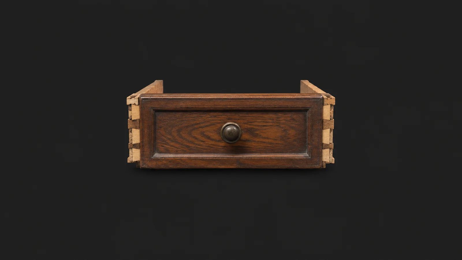 Isolated an oak drawer front with dovetail joints exposed for regluing centred on a seamless deep charcoal near-black studio background, generous empty margin on every side for overlaid branding