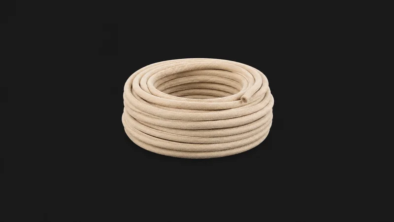 Isolated a coil of piping cord wrapped in calico centred on a seamless deep charcoal near-black studio background, generous empty margin on every side for overlaid branding