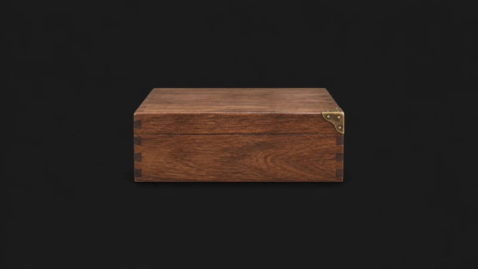 Isolated a wooden document box with a brass corner plate centred on a seamless deep charcoal near-black studio background, generous empty margin on every side for overlaid branding