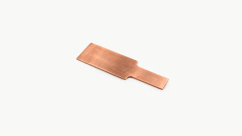 Isolated a battery-cell current collector tab in bare copper centred on a seamless pale off-white studio background, generous empty margin on every side for overlaid branding