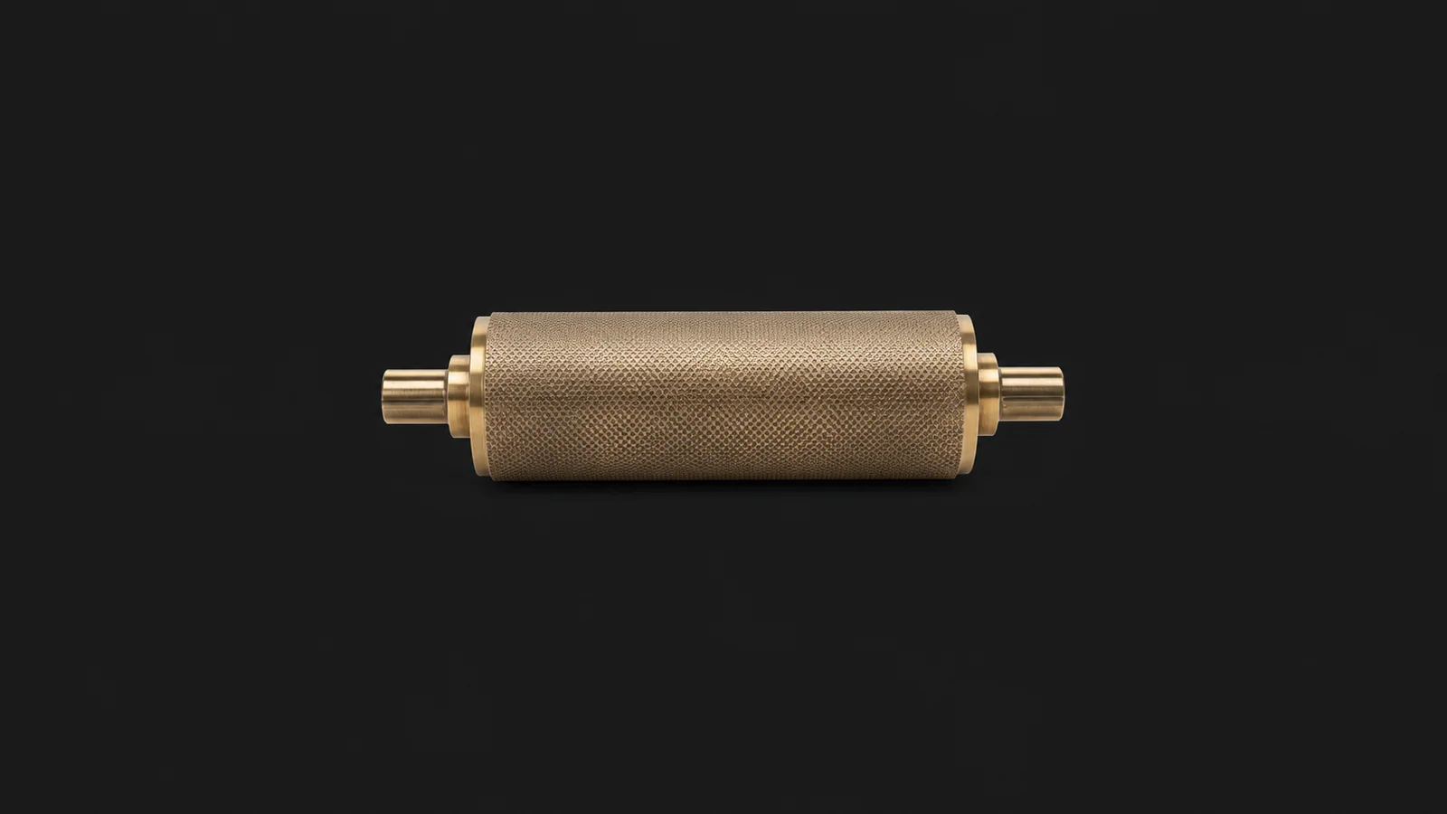 Isolated a brass anilox roller section with a fine cell-pattern surface centred on a seamless deep charcoal near-black studio background, generous empty margin on every side for overlaid branding