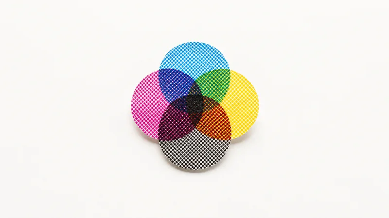 Abstract overlapping CMYK halftone rosettes magnified motif centred on a seamless pale off-white studio background, generous empty margin for overlaid branding